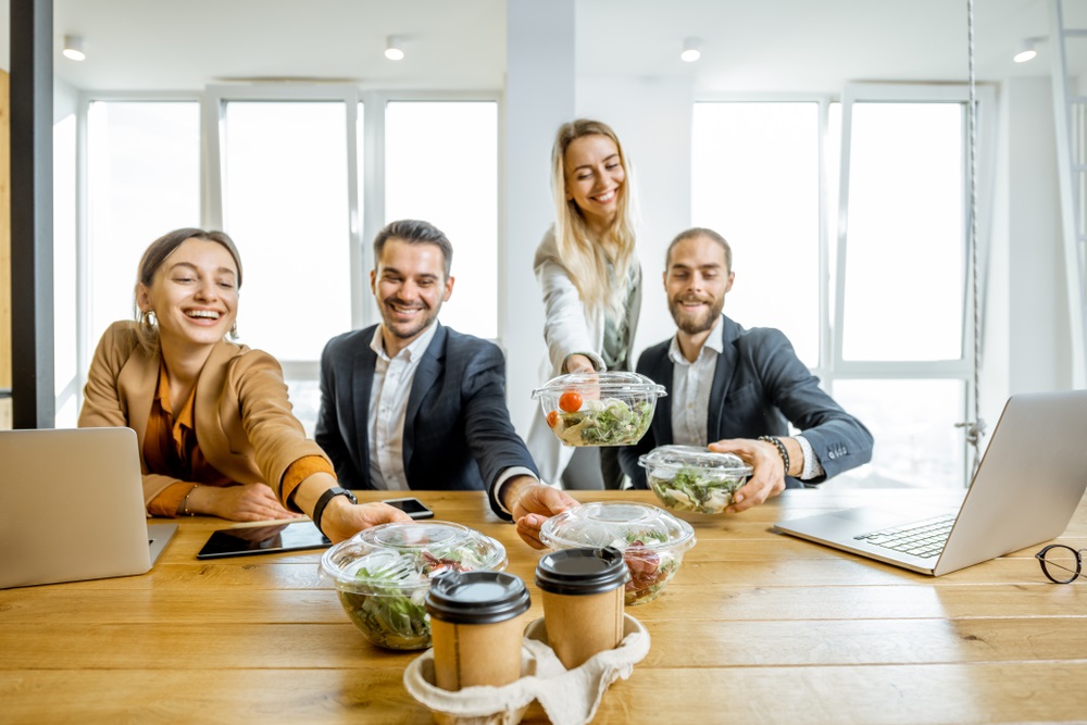 Various types of corporate lunch boxes neatly arranged with diverse food options.