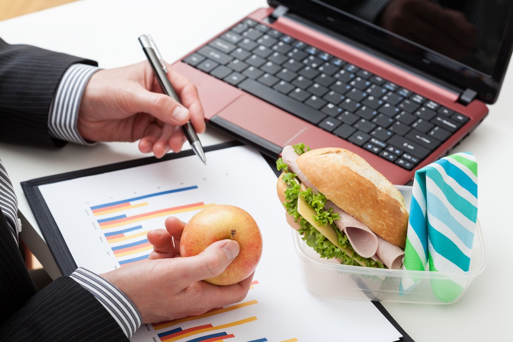 Various types of corporate lunch boxes neatly arranged with diverse food options.