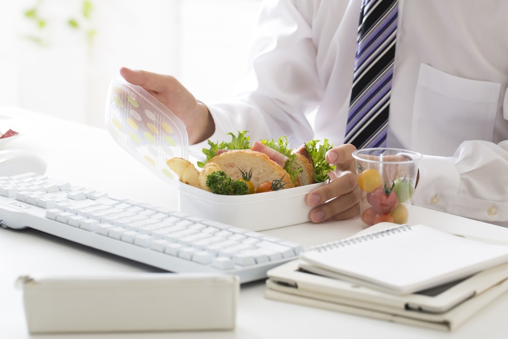 Various types of corporate lunch boxes neatly arranged with diverse food options.