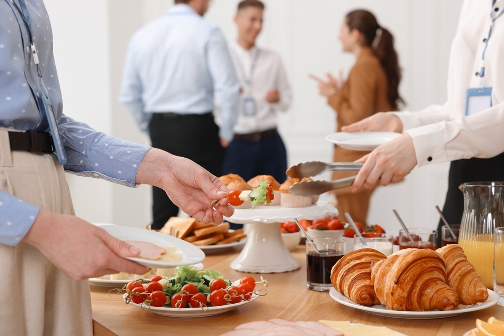 Colleagues enjoying a variety of office lunch ideas for a group in a modern workspace.