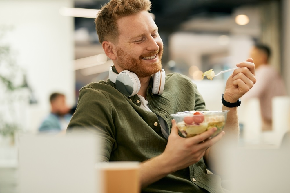 Colleagues enjoying a variety of office lunch ideas for a group in a modern workspace.