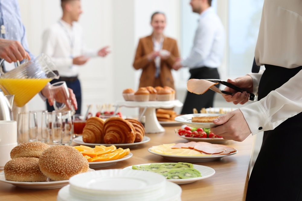 Colleagues enjoying a variety of office lunch ideas for a group in a modern workspace.