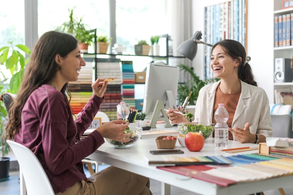 Colleagues enjoying a variety of office lunch ideas for a group in a modern workspace.