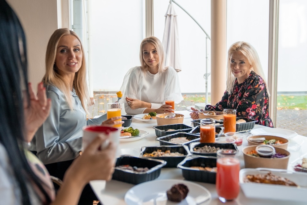 Colleagues enjoying a variety of office lunch ideas for a group in a modern workspace.